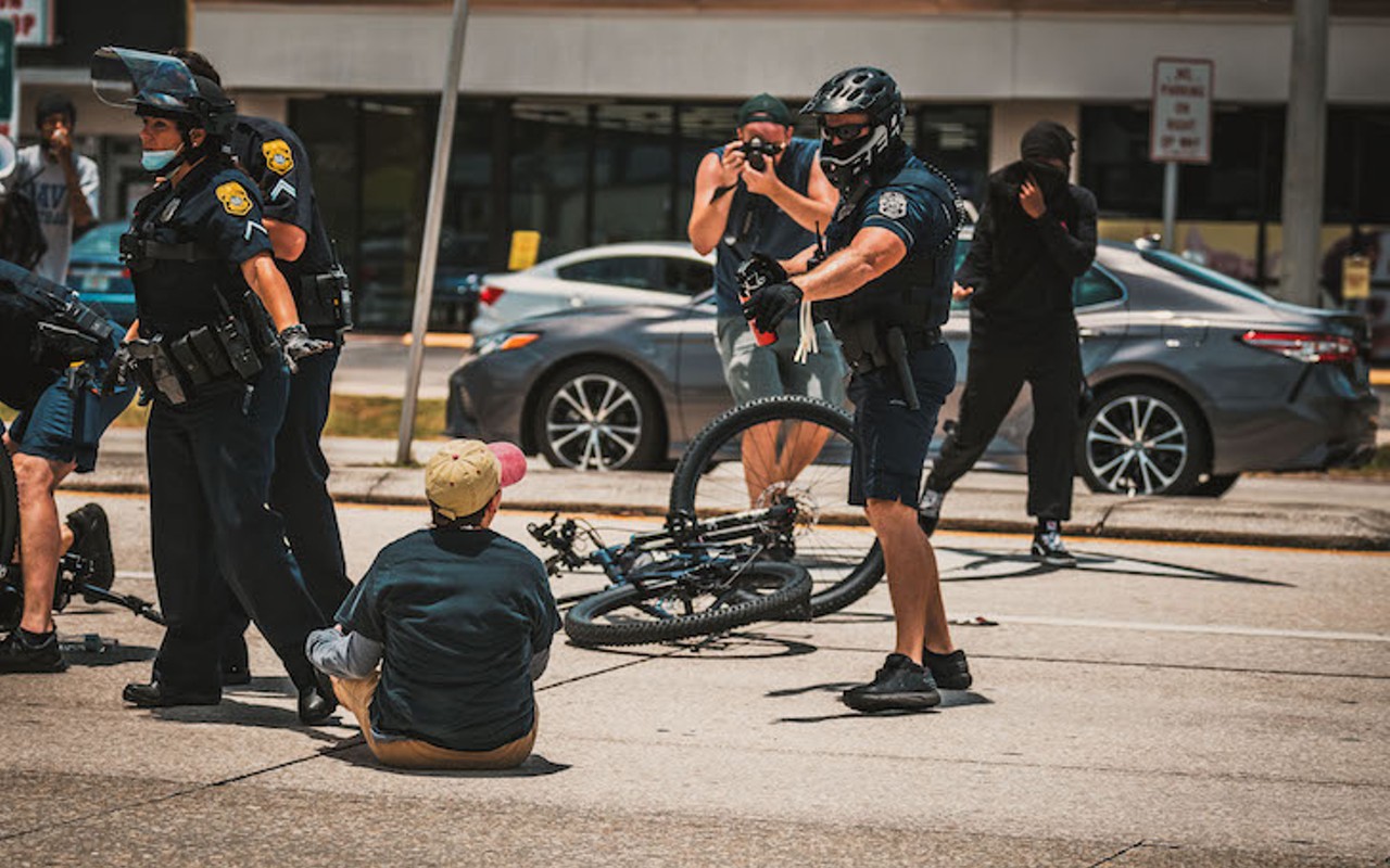 A Tampa police officer aims pepper spray at a Black Lives Matte protester in Tampa, Florida on July 4, 2020.